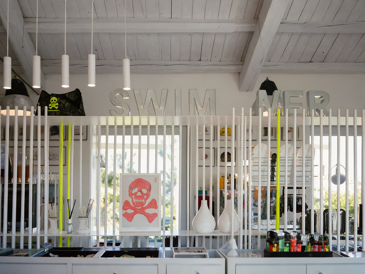 The shop counter with the BONESWIMMER skull on the slatted wall